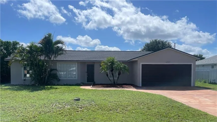 Ranch-style home with stucco siding, driveway, and a front lawn