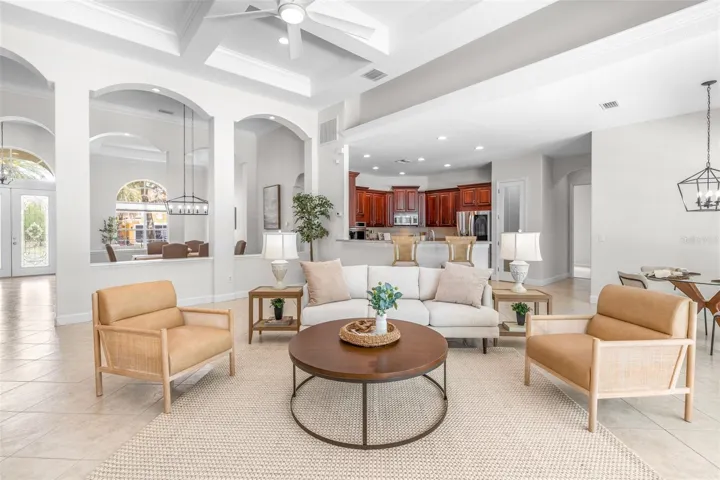 Bright and inviting great room with coffered ceilings and picturesque conservation views