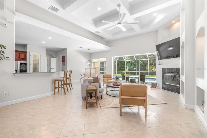 Expansive open-concept living space with custom ceiling details and seamless indoor-outdoor flow through pocket sliding glass doors