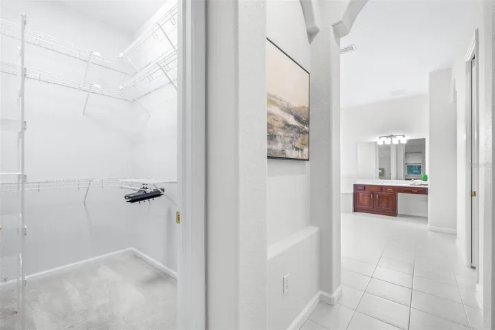 Spa-inspired primary bath with dual closets and separate water closet with additional cabinet space