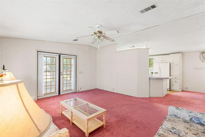 LIVING ROOM. FRENCH DOORS LEAD TO ENCLOSED PORCH