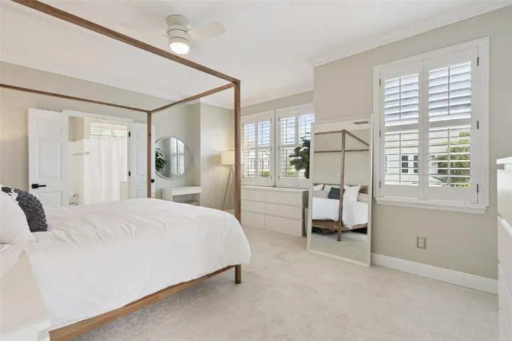 Generous sized primary bedroom with plantation shutters.