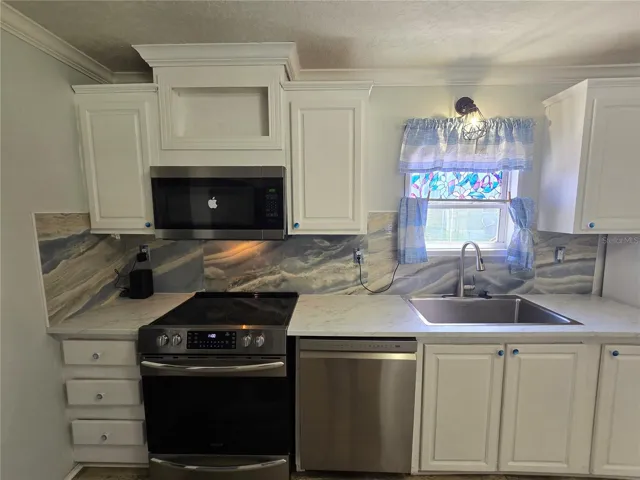 Newer appliances. Stainless steel farm style sink.