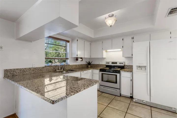 Kitchen has granite counters and tile floors throughout