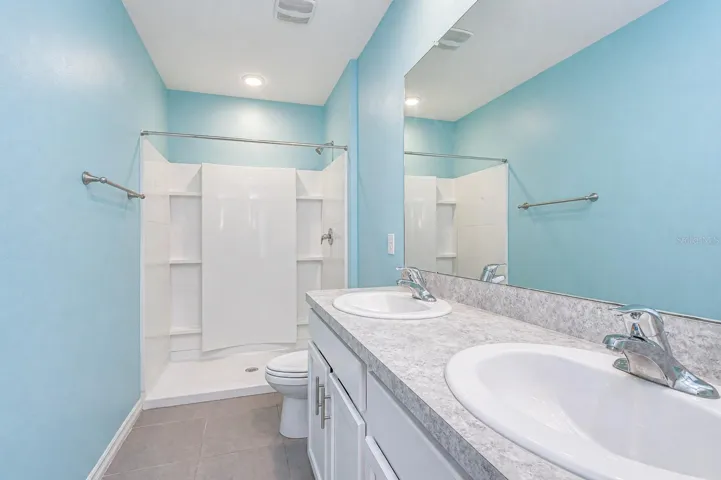 Upstairs, the Primary Suite features dual vanities, a walk-in shower, and two walk-in closets.