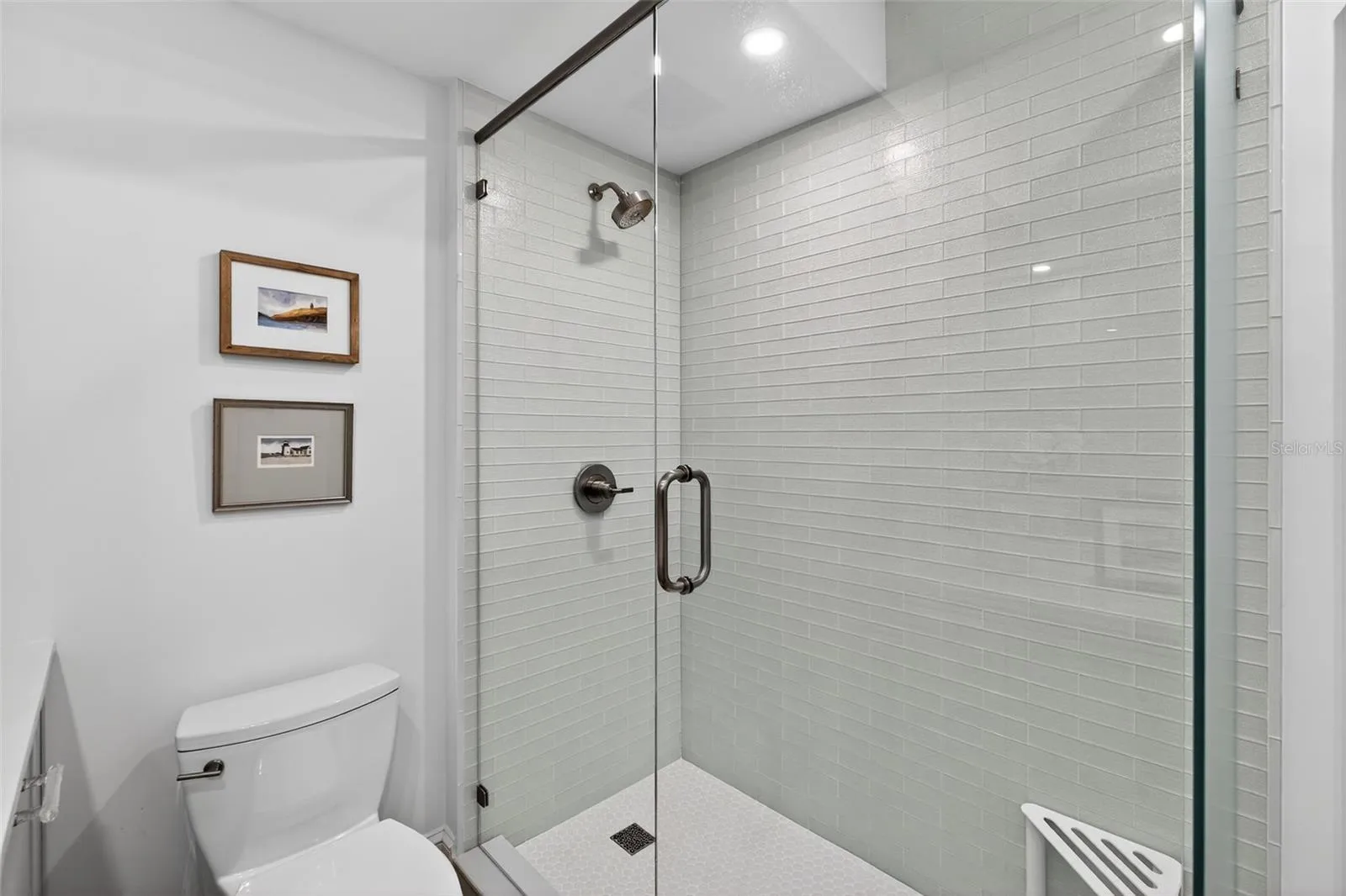 Walk-in shower with timeless classic tile and a sleek glass enclosure.