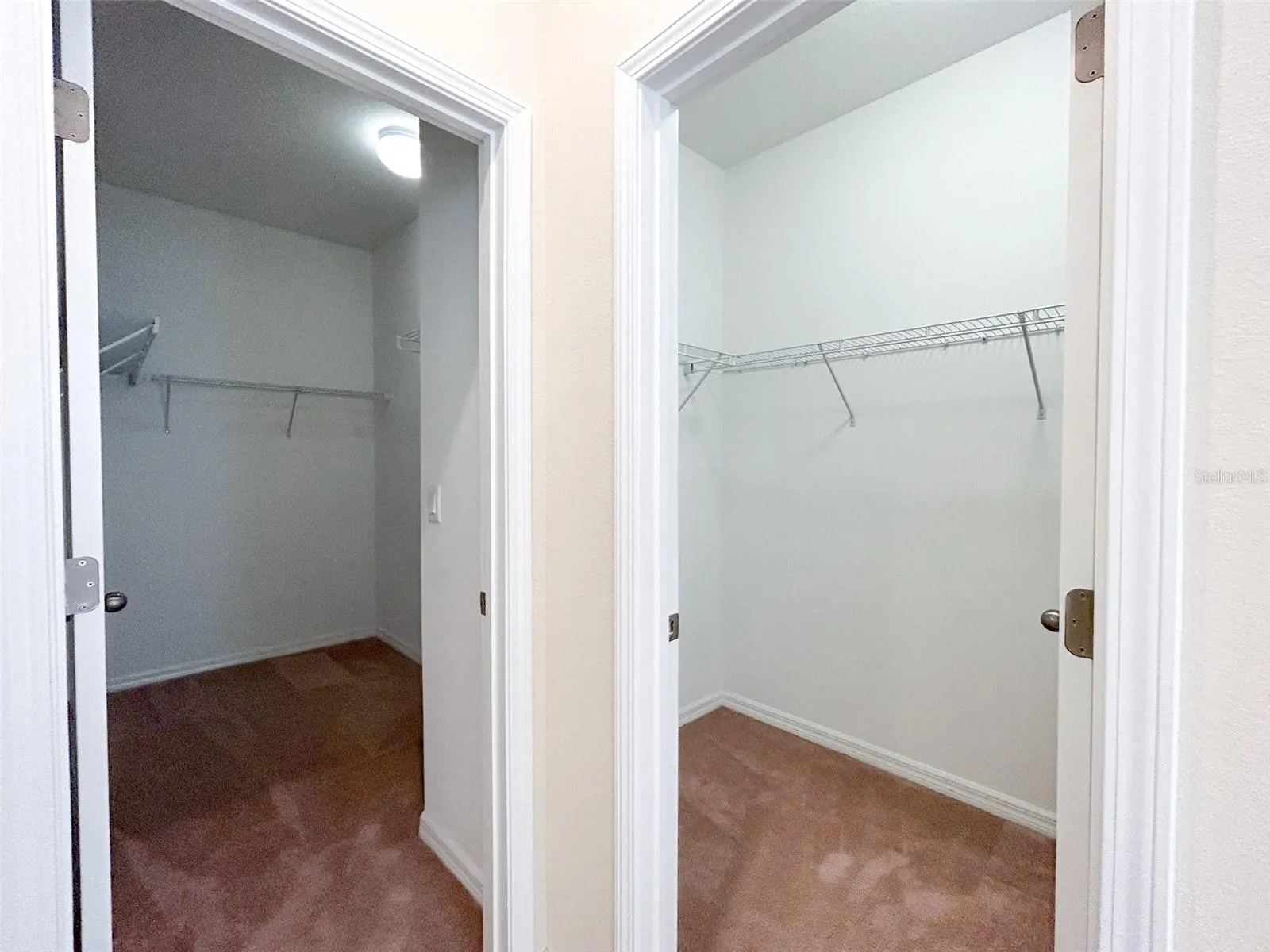 Primary bath with two separate walk-in closets with individual