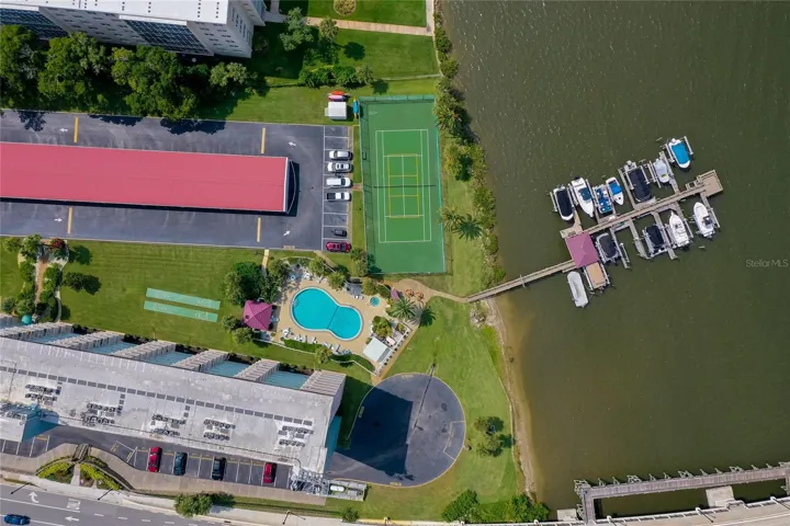Scenic overhead view featuring the on-site tennis court alongside the waterfront and dock area.