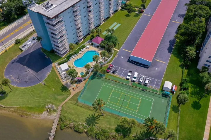 Bird’s-eye view highlighting the community pool, tennis court, and beautifully maintained grounds.