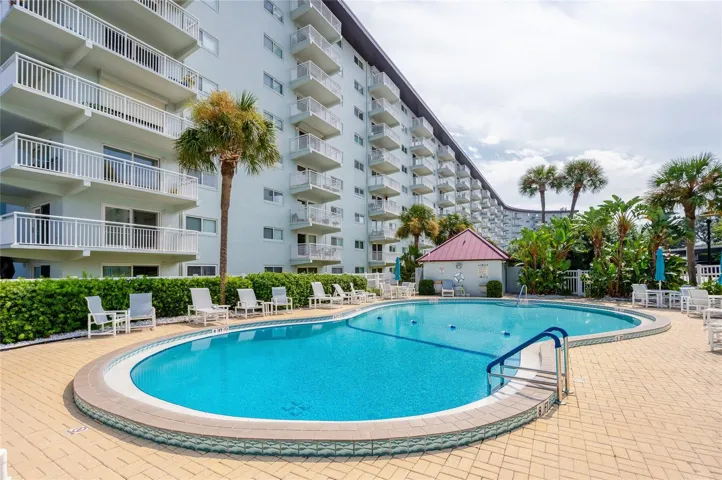 Inviting resort-style pool surrounded by lounge seating, offering a relaxing setting to enjoy sunny days.