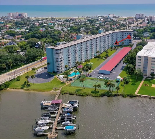 Elevated perspective showcasing the building’s proximity to the water, nearby beach access, and surrounding neighborhood.