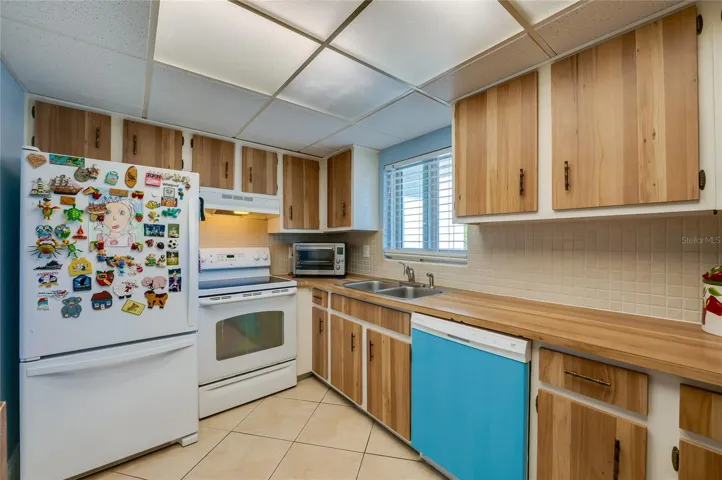 Bright workspace featuring generous storage, double sink, and efficient appliance placement for easy use.