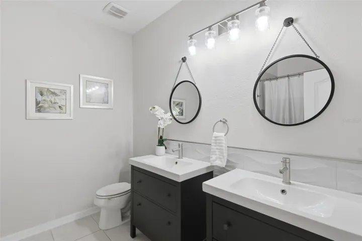 Hall bathroom with shower/tub combo & two vanities