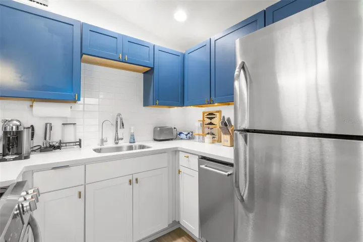 Bold two-tone cabinetry, gold hardware, and designer pendant lighting add elevated contemporary style.