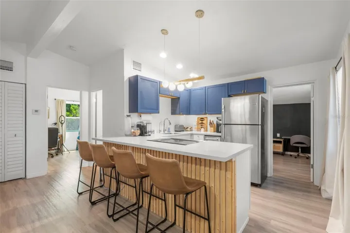 Corian countertops and custom wood-accent island create a stylish focal point.
