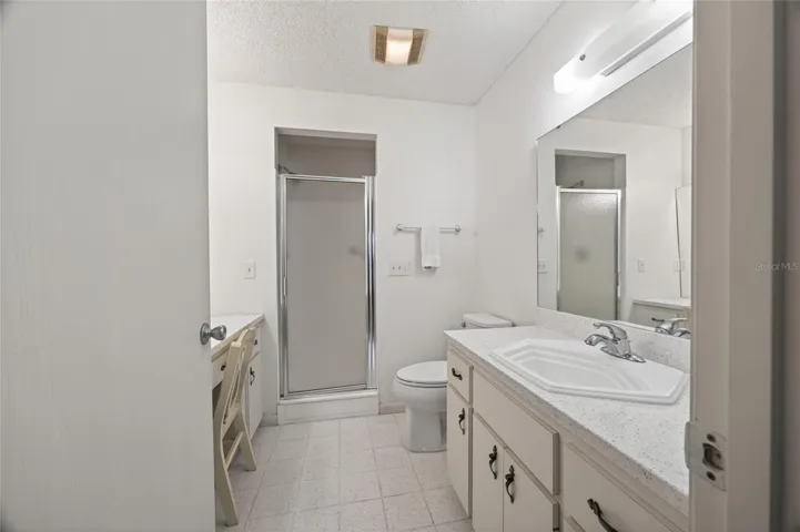 Ensuite primary bedroom with separate dressing table vanity and walk in shower.