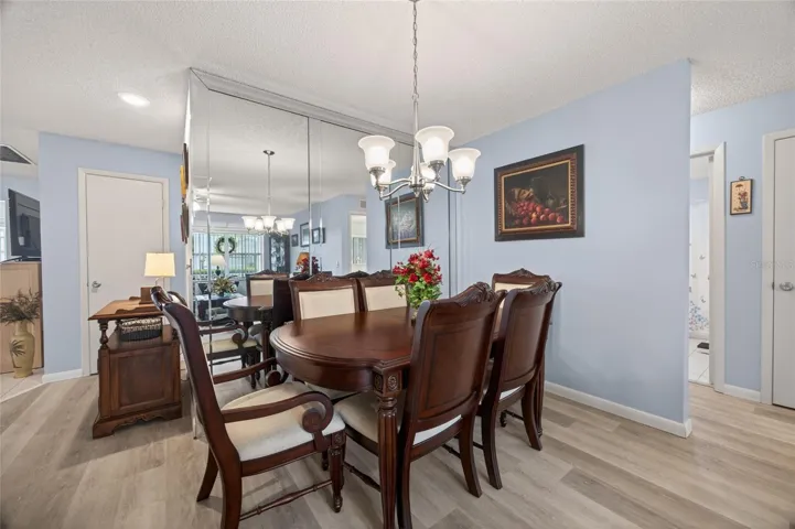 Dining room with chandelier upgraded mirror encased wall and room for a side table or buffeet.