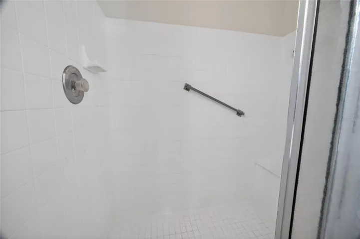 Primary shower has grab bar and built in tiled seat.