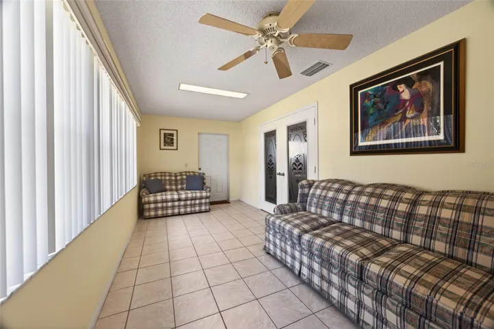 View of French door to the primary bedroom and patio door. Vertical window blinds.