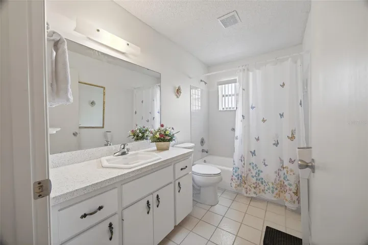 Second bathroom with large vanity and tub.