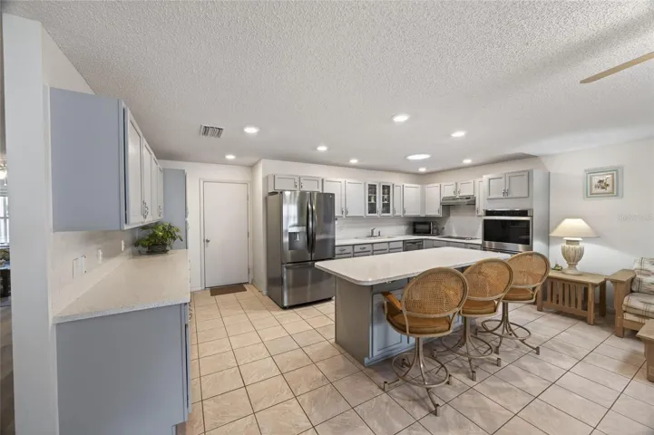 Large kitchen island has room to eat, food preparation and entertaining. Storage cabinets under the island.