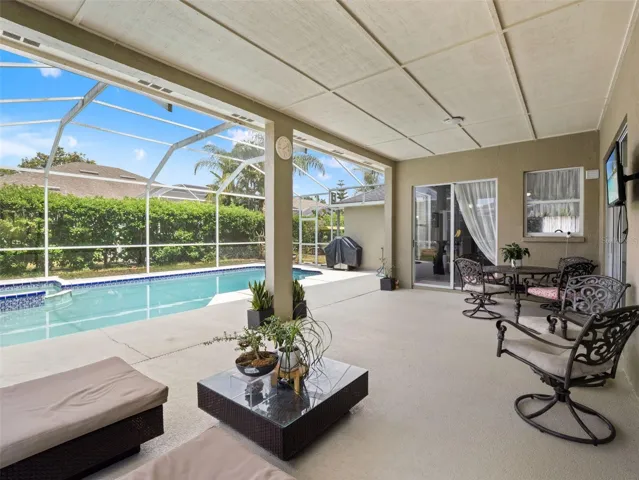 Expansive covered outdoor living space with ceiling panels for shade and comfort, offering seamless indoor-outdoor flow.