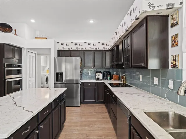 Thoughtfully arranged kitchen with generous counter space, modern finishes, and easy access to the laundry room and surrounding living spaces.