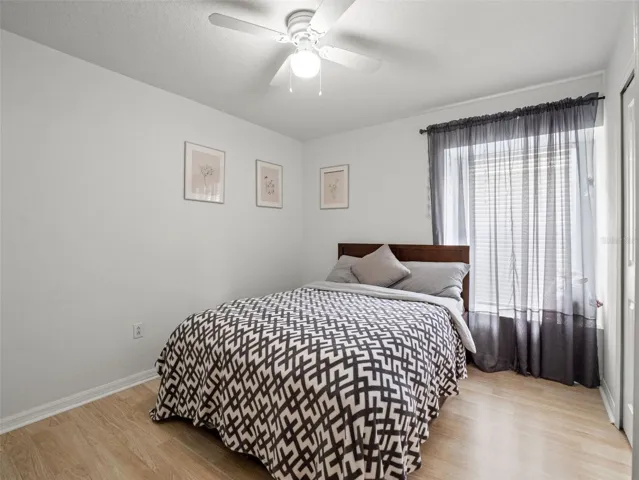 Comfortable secondary bedroom with natural light, neutral finishes, and ample space for guests or family.