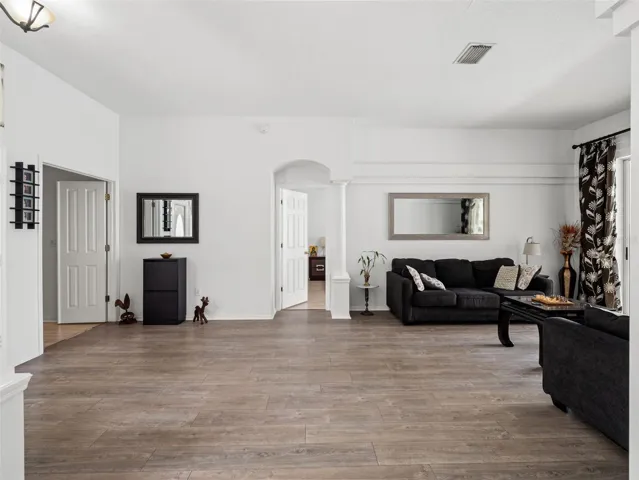 Expansive open living area with wood-style flooring and neutral finishes, offering plenty of room for both relaxing and entertaining.