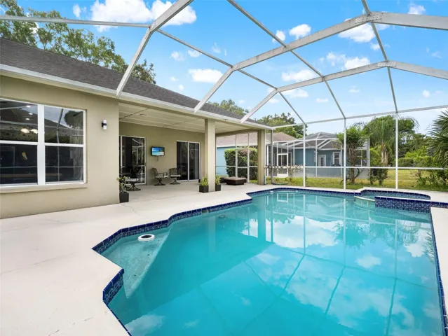 Serene backyard retreat with screened enclosure, combining open sky views with the comfort of a private outdoor setting.