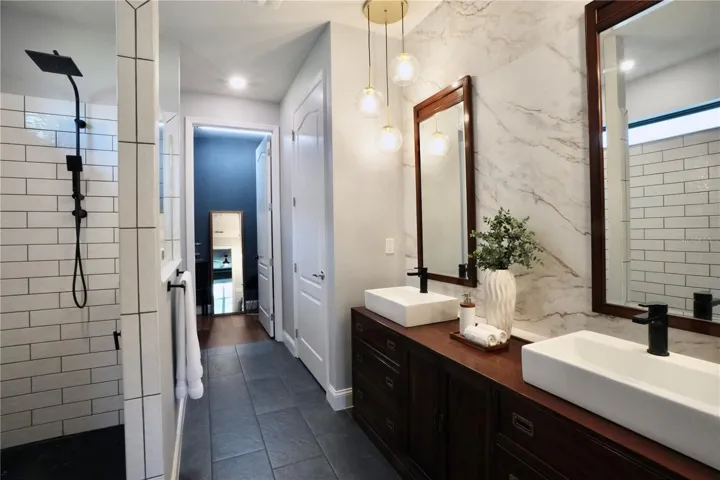 Primary en-suite bathroom with tile floors, walk-in shower, double sink vanity, walk-in closet and private water closet.
