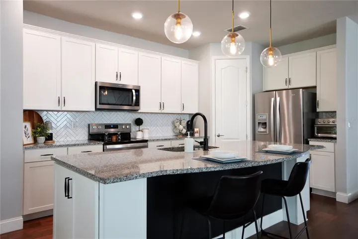 Walk-in corner pantry, backsplash, upgraded faucet and cabinet hardware.