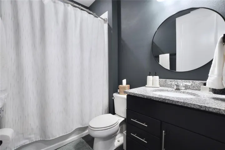 Bathroom 2, with tile floor and extended height vanity with granite countertop.