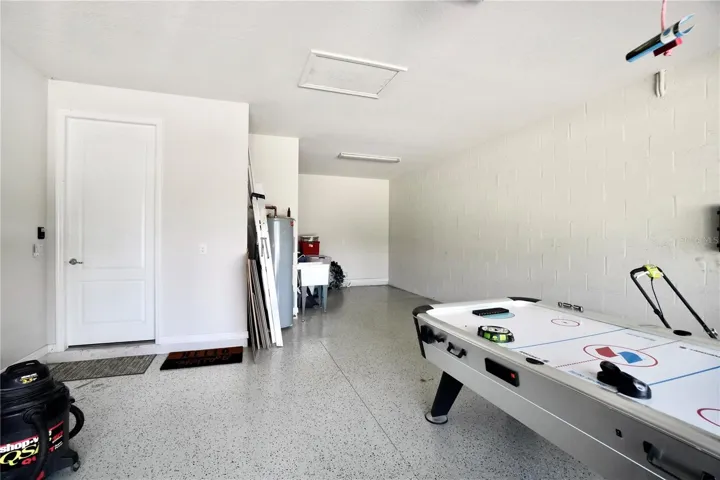 Oversized 2 car garage with epoxy floor and extended tandem space, adding additional storage, or use for workout space or hobby area.