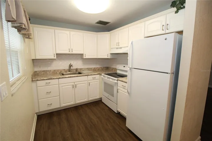 Kitchen is bright and clean, featuring good cabinet space and lovely countertops.
