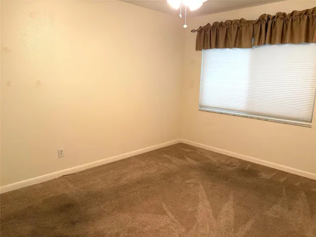 Primary bedroom with light filtering window blinds.