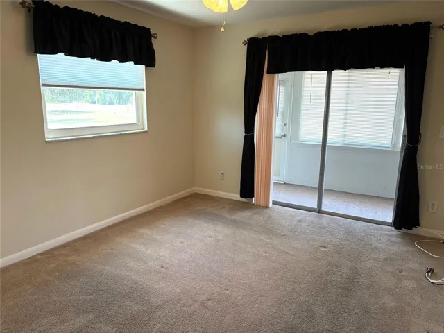 Guest bedroom with sliding glass doors leading to enclosed lanai.