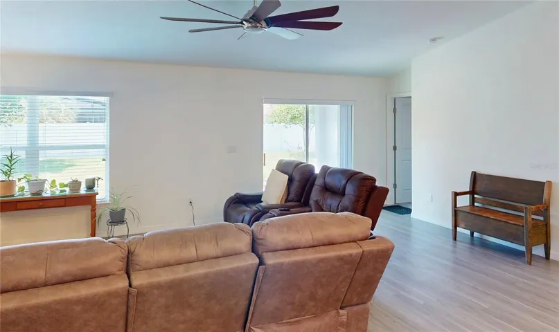 The living area is beautifully oriented toward the sliding glass doors, creating a natural transition to the covered lanai and inviting indoor-outdoor living.