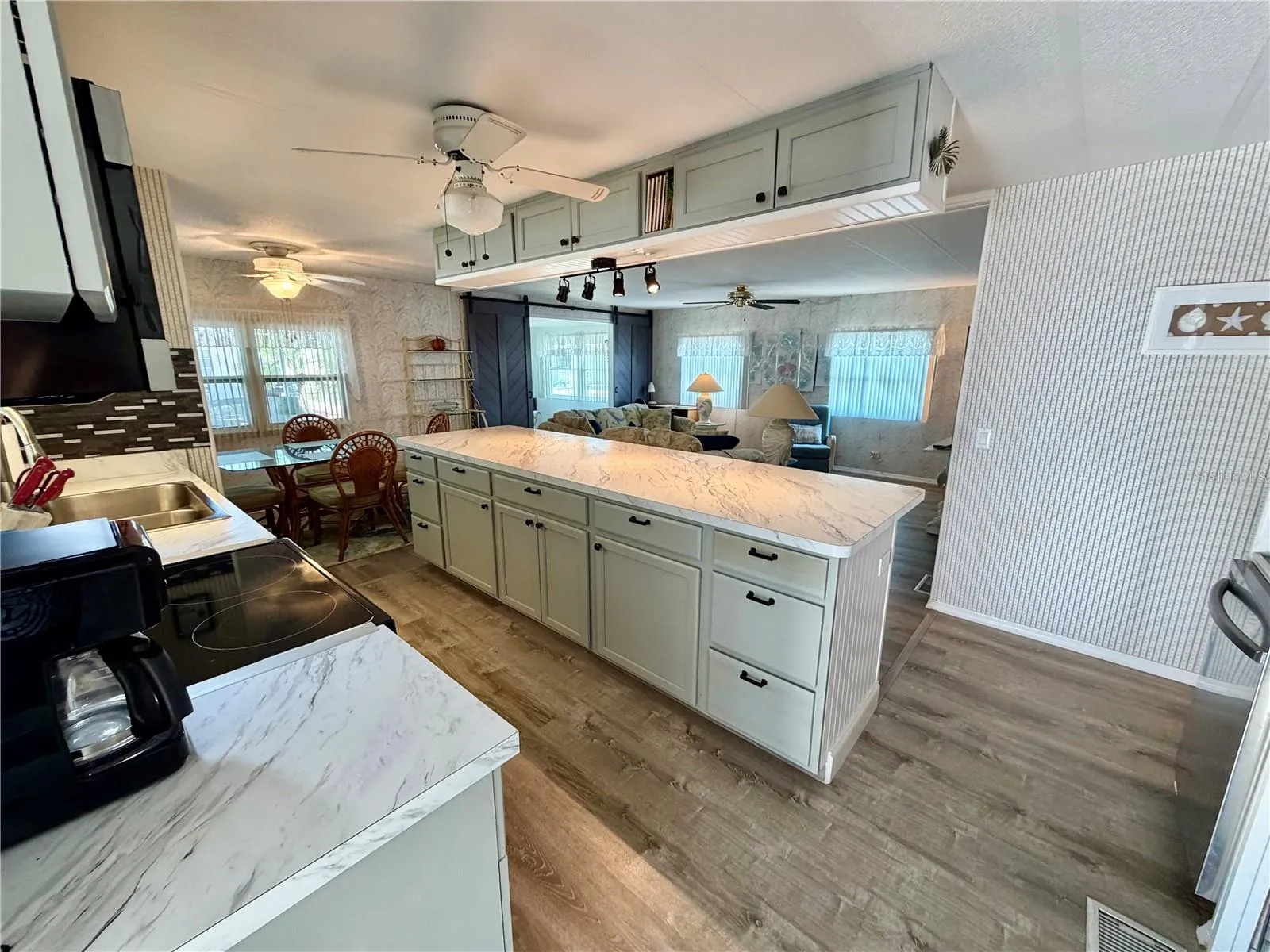 Walking in side door… vinyl plank flooring. Large island, total OPEN concept!