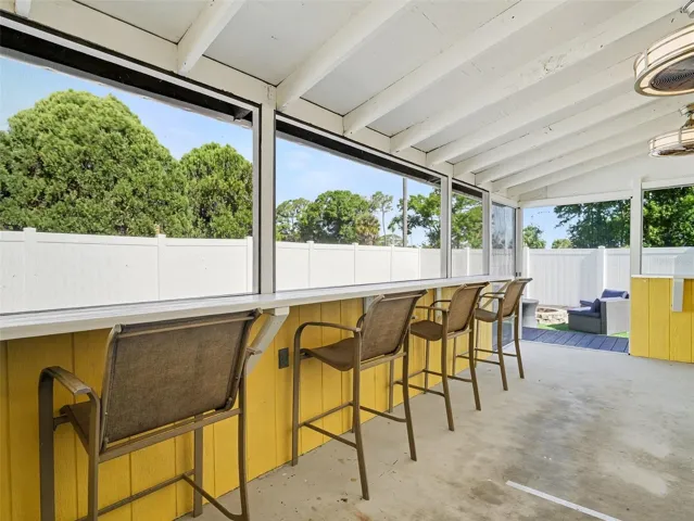 Screened in porch sitting area with bar