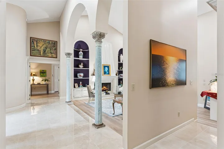 Marble Hallway leading to Powder Room, Living Room Wet Bar area and Primary Bedroom.