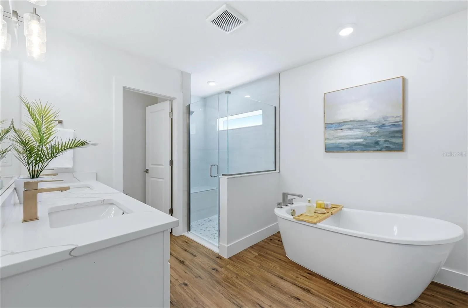 Primary en suite bathroom with soaker tub, dual vanity, shower and separate water closet