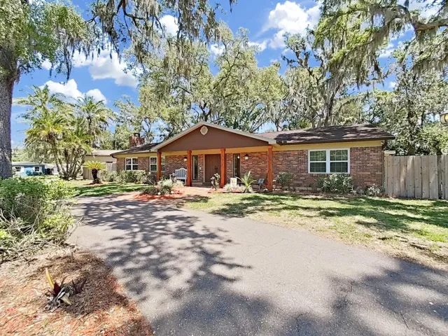 The circle drive leads to this sprawling brick ranch-style home with a welcoming covered front porch entry.