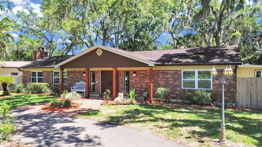 Lovely front elevation with brick paver courtyard, wood beam covered entry and stunning backdrop of mature trees. Curb appeal at its finest!