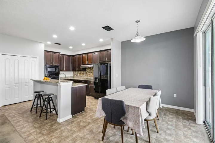 The kitchen is the heart of the home, featuring rich cabinetry, GRANITE COUNTERTOPS, a large ISLAND with breakfast bar seating, BUILT-IN OVEN and microwave, and a generous pantry for storage!