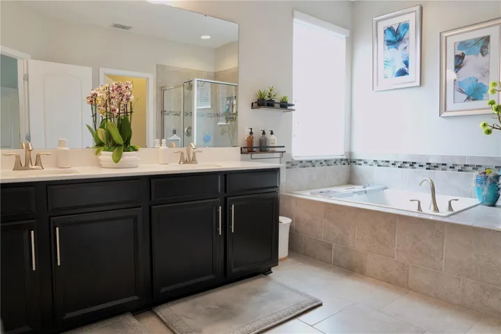 Primary bathroom with tile floors and an extended height, double sink vanity.