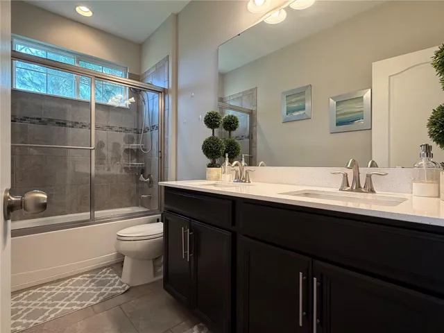 Secondary bathroom with tub / shower combo and double sink, extended height vanity is located between bedroom 3 & 4.