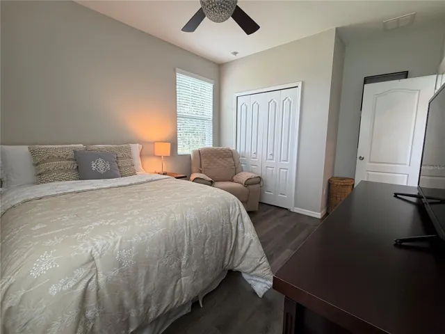 Bedroom 4 with built-in closet, ceiling fan and luxury vinyl plank flooring.