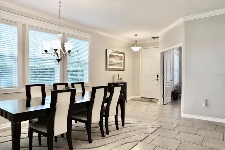 Dining Room with custom window casings, crown molding and tile floors. Double door on the right leads to the flex space that is currently a home office.
