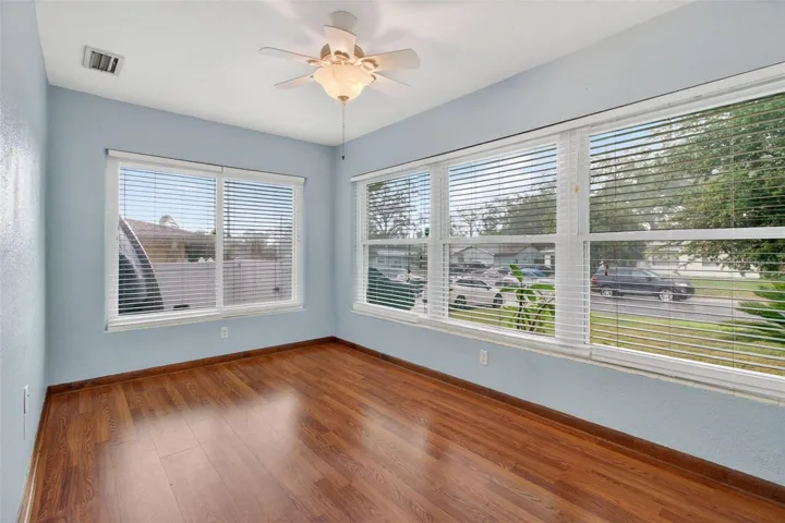 Primary Bedroom is light and bright with a wall of windows and laminated flooring.